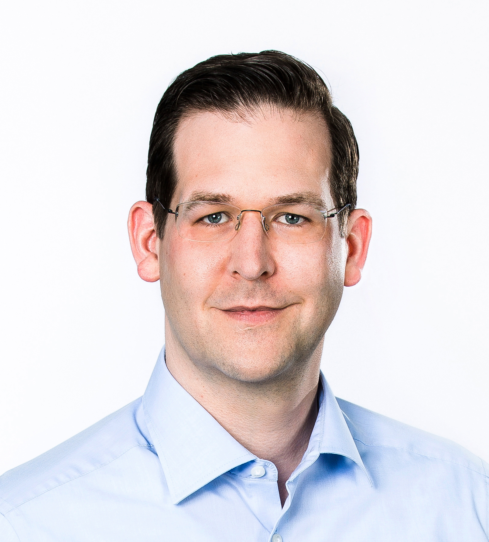 Portrait des Geschäftsführers Tobias Krautkremer in einem hellblauen Hemd vor einem weißen Hintergrund