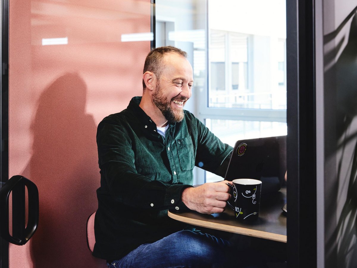 Einer der Geschäftsführer hält ein Online-Meeting in einer schalldichten Telefonzelle
