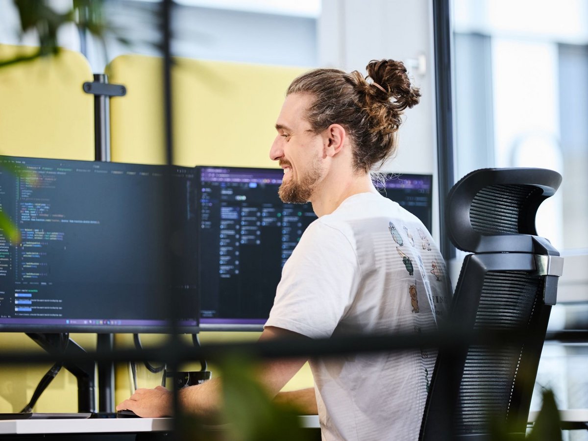 Ein lise-Entwickler mit einem Dutt nutzt auf dem Computer vor ihm Infrastructure as Code