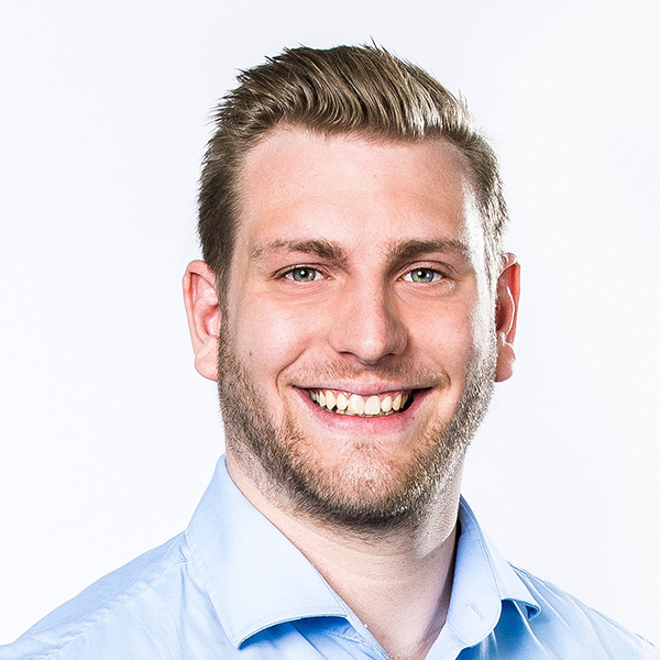 Ein Portrait von dem Product Manager Marvin Hecker in einem blauen Hemd vor einer weißen Wand