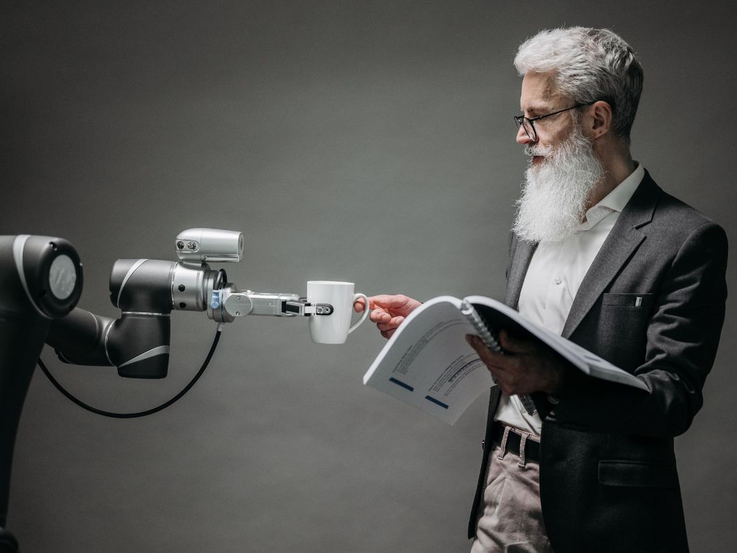 Ein Roboter reicht einem Menschen einen Kaffee.