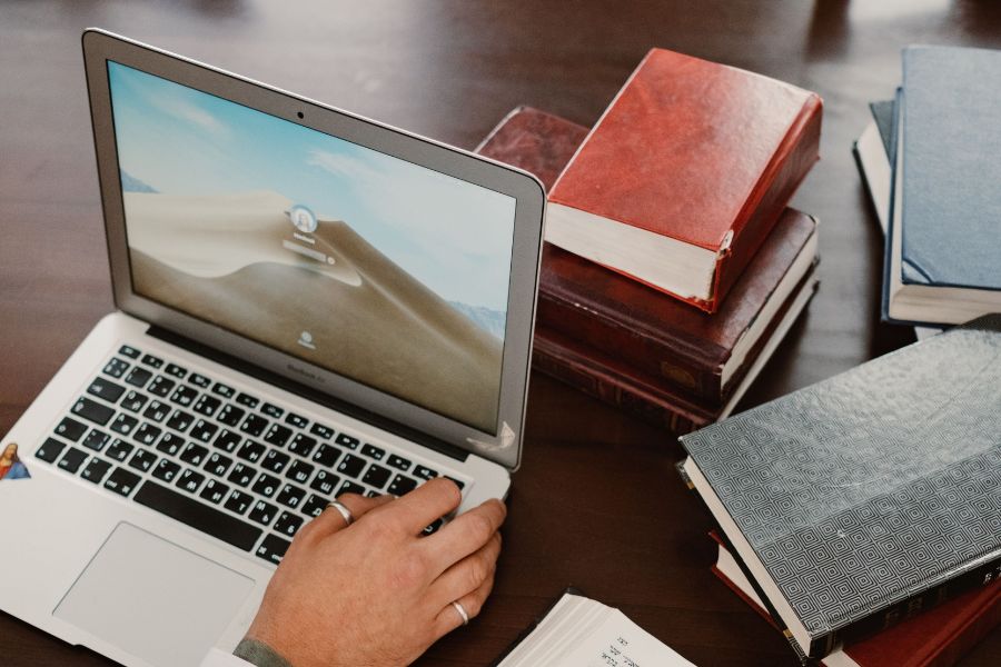 Von der Forschung zur technischen Umsetzung Ein neuer Computer steht auf einem Tisch neben mehreren älteren Büchern.